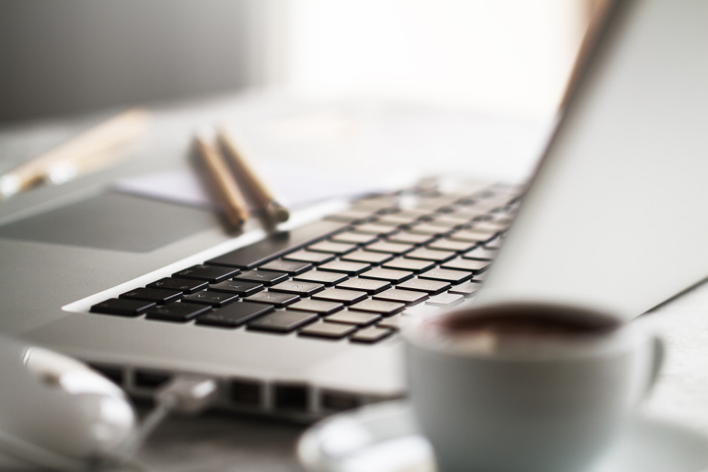 Closeup of Workspace with Modern Creative Laptop, Cup of Coffee